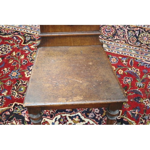 363 - Antique English hall chair with shield back, standing on turned front legs