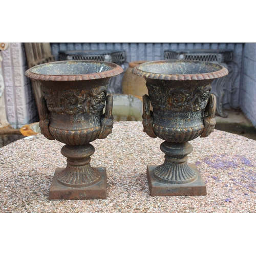 295 - Pair of antique French cast iron twin handled garden urns, nicely decorated and with male faces to t... 