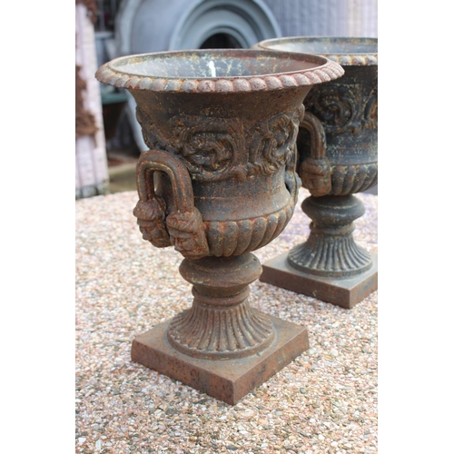 295 - Pair of antique French cast iron twin handled garden urns, nicely decorated and with male faces to t... 