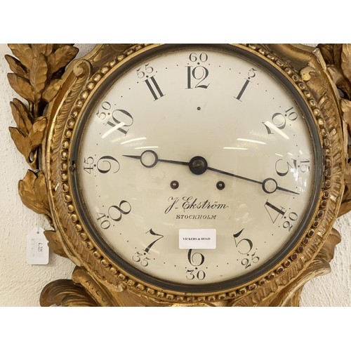 1011 - A Swedish rococo carved gilt wood cartel clock, the 10 in painted convex dial inscribed 'J Ekstrom, ... 