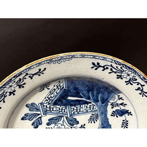 1351 - Antique 18th century Delft blue and white charger, decorated with trellis fence and pine tree, circa... 
