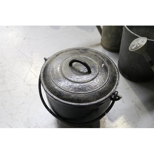 46 - Cast iron pot standing on legs, swing handled and with lid, approx 44cm H ex handle x 41cm Dia