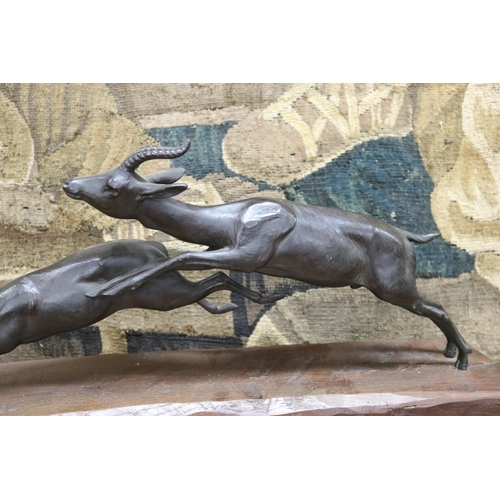 55 - French sculpture of two antelope running, mounted to a wooden plinth base, marked FRANCE to figure, ... 