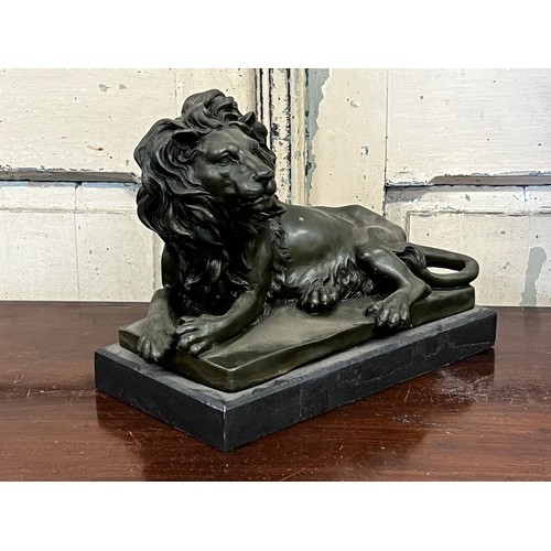 1037 - Bronze of a recumbent lion, after Barye, on a black marble base, approx 20cm H x 32cm W x 15cm D
