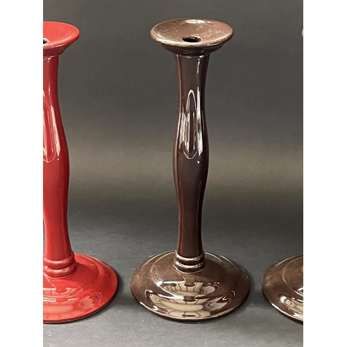 167 - Pair of brown candle sticks plus a red example, each approx 30cm H (3)