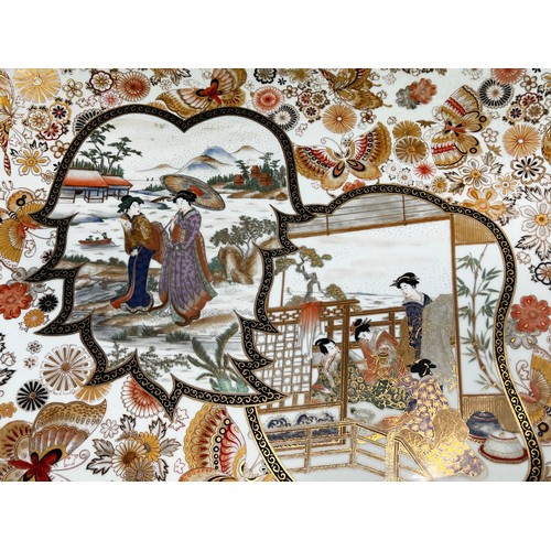 13 - Large Japanese porcelain charger, painted to the centre with leaf form panels, figures in outdoor an... 