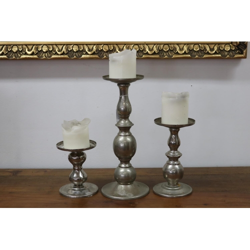 1091 - Three decorative metal candlesticks, approx 31cm H (ex candle) and shorter (3)