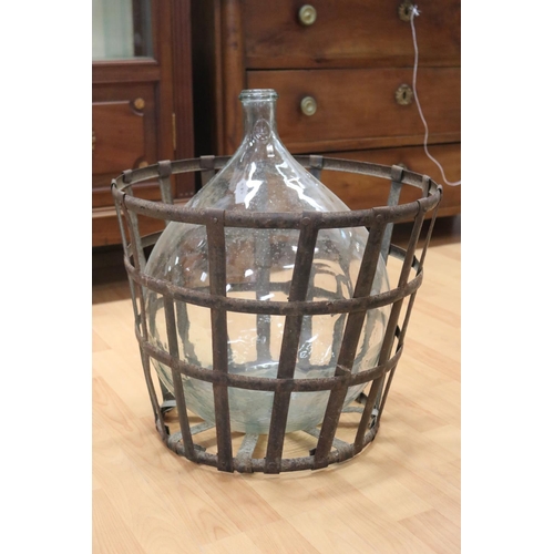 1110 - Antique French clear glass wine bottle in metal cradle, approx 50cm H x 50cm Dia