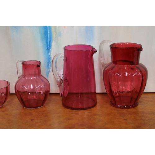 225 - Three ruby glass jugs and three bowls, approx 21cm H and shorter (6)