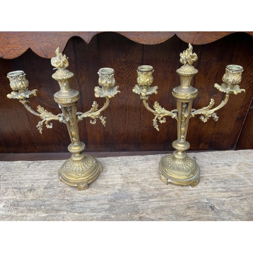 174 - Pair of antique French Louis XVI revival bronze two stick candelabra, each with central flaming torc... 