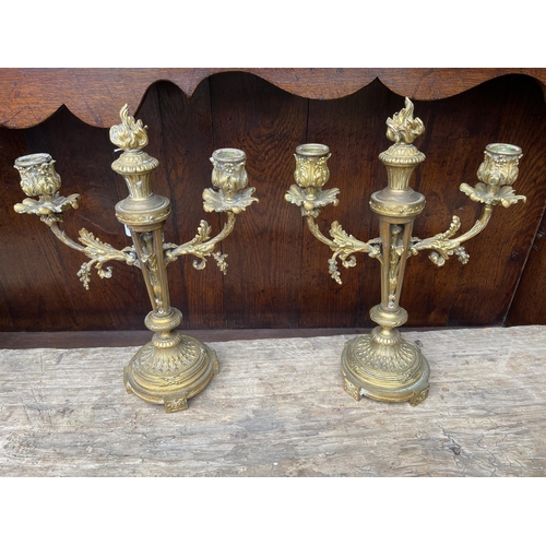 174 - Pair of antique French Louis XVI revival bronze two stick candelabra, each with central flaming torc... 