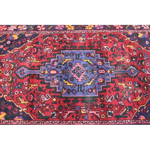1040 - Handwoven red ground carpet, approx 240cm x 130cm