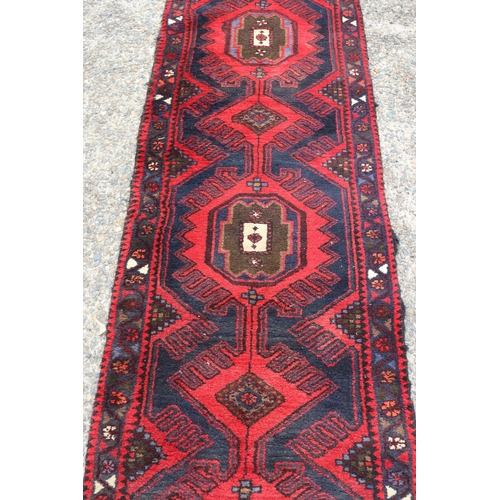 1030 - Old handwoven hall runner of red ground, approx 296 x 71cm