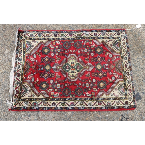 1188 - Handwoven red ground carpet, approx 63cm x 87cm