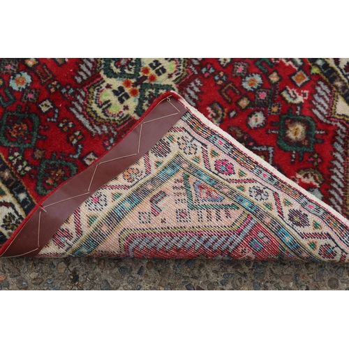 1188 - Handwoven red ground carpet, approx 63cm x 87cm