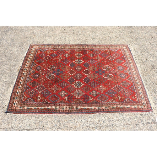 1249 - Handwoven wool carpet of red ground, approx 153cm x 107cm