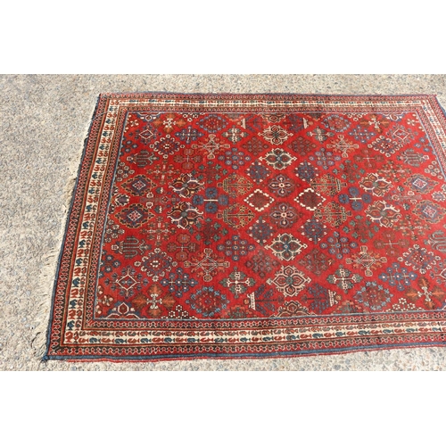 1249 - Handwoven wool carpet of red ground, approx 153cm x 107cm