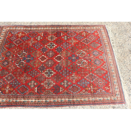 1249 - Handwoven wool carpet of red ground, approx 153cm x 107cm