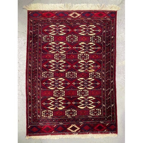 1302 - Handwoven wool carpet of red ground, approx 92cm x 135cm