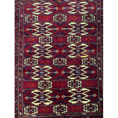 1302 - Handwoven wool carpet of red ground, approx 92cm x 135cm