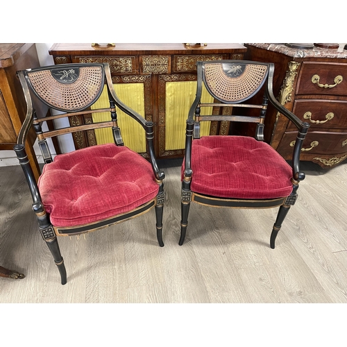 10 - Pair of Regency style ebonized caned armchairs with loose button cushions. (one seat cane is damaged... 
