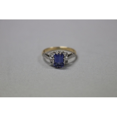 1252 - RETURNED 13/7/24 - 18ct white and yellow gold ring, claw set created emerald cut sapphire flanked by... 