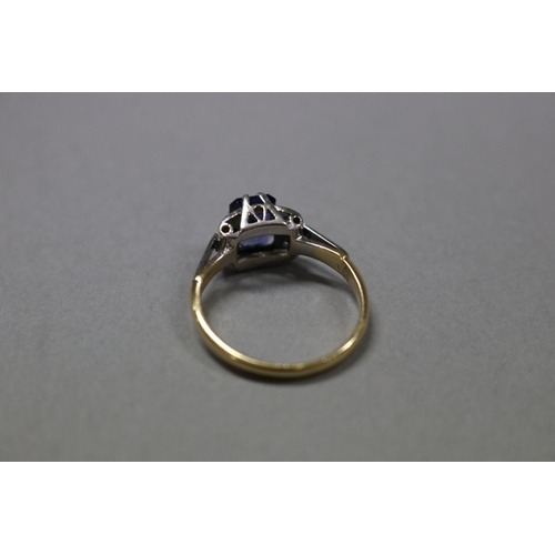 1252 - RETURNED 13/7/24 - 18ct white and yellow gold ring, claw set created emerald cut sapphire flanked by... 