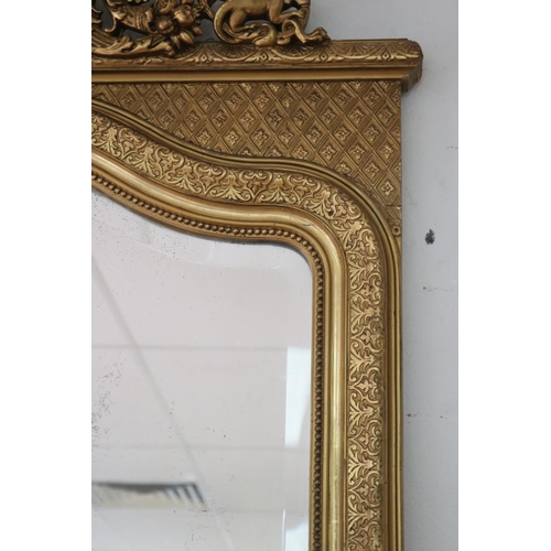 1034 - Antique French gilt salon mirror, surmounted with scrolling central crest, the frame decorated in re... 