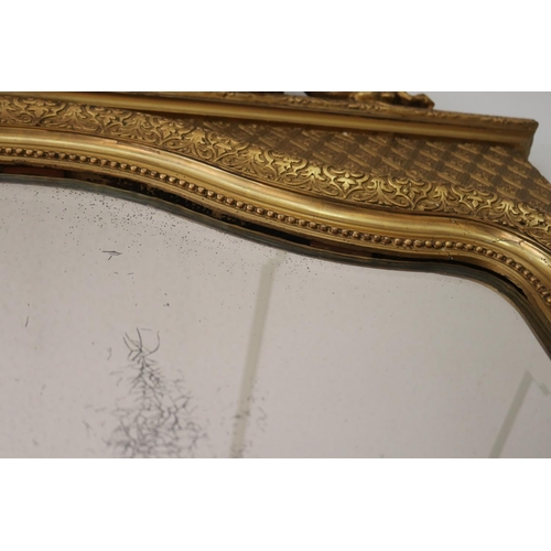 1034 - Antique French gilt salon mirror, surmounted with scrolling central crest, the frame decorated in re... 