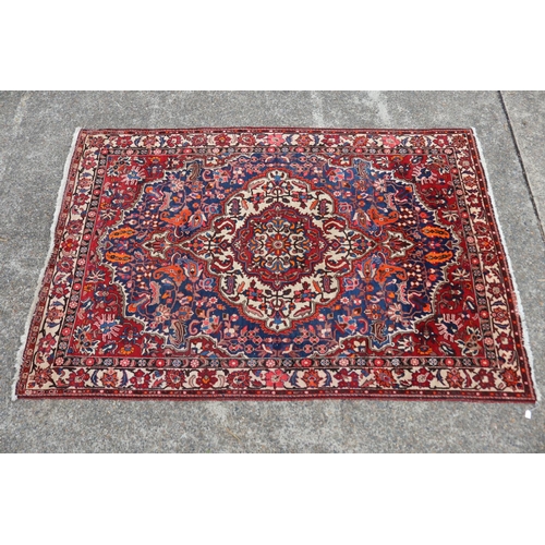 1130 - Large Persian handwoven wool carpet of red ground with central medallion, approx 315cm L x 207cm W