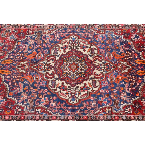 1130 - Large Persian handwoven wool carpet of red ground with central medallion, approx 315cm L x 207cm W