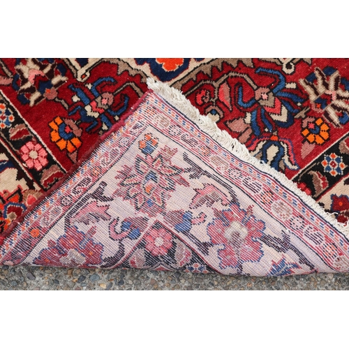 1130 - Large Persian handwoven wool carpet of red ground with central medallion, approx 315cm L x 207cm W