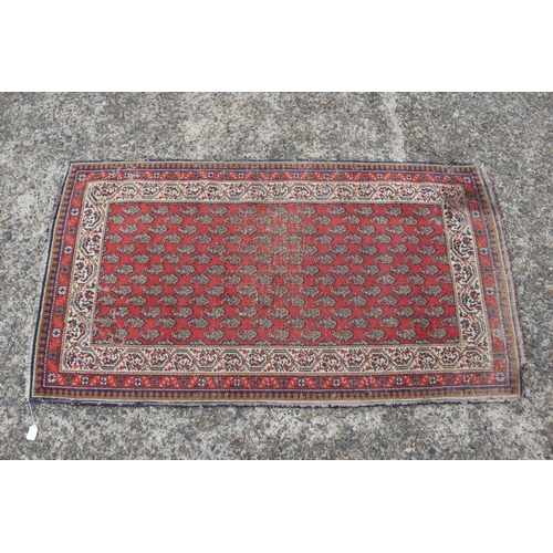 1157 - Persian handwoven wool carpet of red ground, multi borders to edge, approx 88cm x 159cm