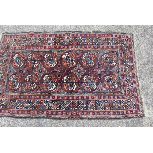 1159 - Persian handwoven wool carpet of red ground, central bosses, approx 196cm x 121cm