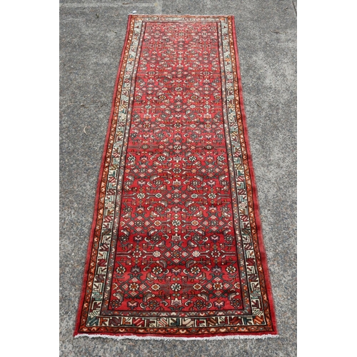 1163 - Persian handwoven wool carpet of red ground, with traditional border, approx 116cm x 339cm