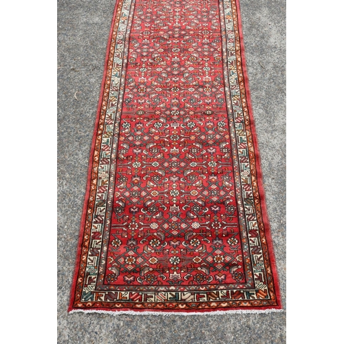 1163 - Persian handwoven wool carpet of red ground, with traditional border, approx 116cm x 339cm