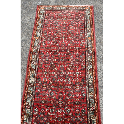 1163 - Persian handwoven wool carpet of red ground, with traditional border, approx 116cm x 339cm