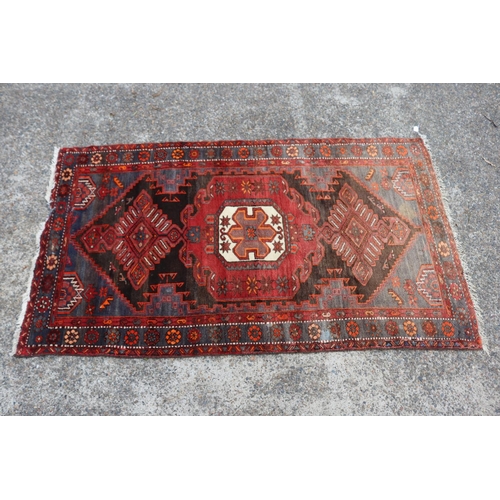 1164 - Persian handwoven wool carpet of red ground, central medallion, showing wear & age, approx 135cm x 2... 