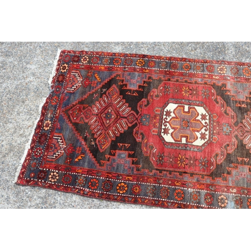 1164 - Persian handwoven wool carpet of red ground, central medallion, showing wear & age, approx 135cm x 2... 