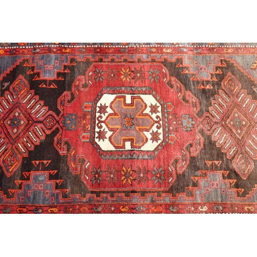 1164 - Persian handwoven wool carpet of red ground, central medallion, showing wear & age, approx 135cm x 2... 