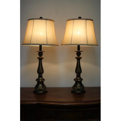 1209 - Pair of decorative black and gilt table lamps, cream shantung shades, in working order at the time o... 