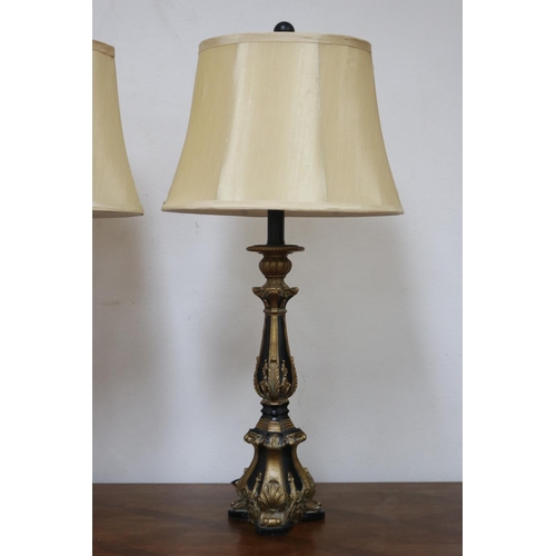 1209 - Pair of decorative black and gilt table lamps, cream shantung shades, in working order at the time o... 