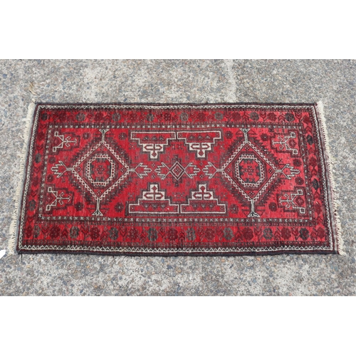 1216 - Persian handwoven wool carpet of red ground, double diamond & geometric design, approx 81cm x 157cm