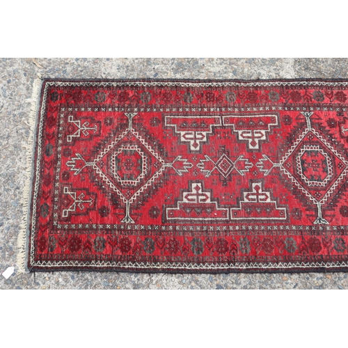 1216 - Persian handwoven wool carpet of red ground, double diamond & geometric design, approx 81cm x 157cm