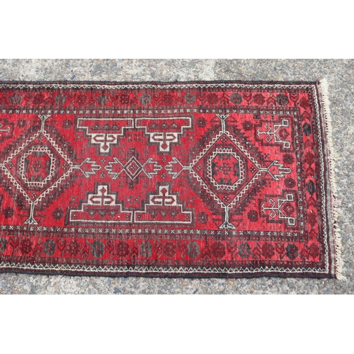 1216 - Persian handwoven wool carpet of red ground, double diamond & geometric design, approx 81cm x 157cm