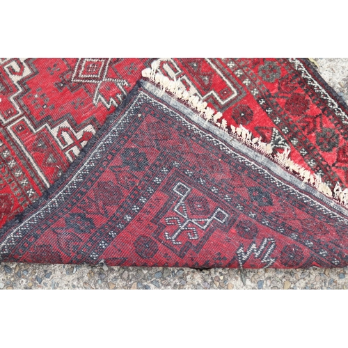 1216 - Persian handwoven wool carpet of red ground, double diamond & geometric design, approx 81cm x 157cm