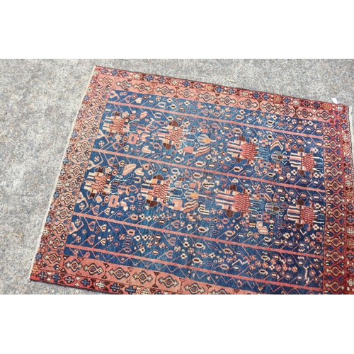 1226 - Persian handwoven wool carpet of blue & red ground, approx 158cm x 130cm