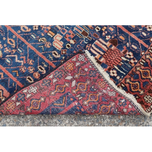 1226 - Persian handwoven wool carpet of blue & red ground, approx 158cm x 130cm