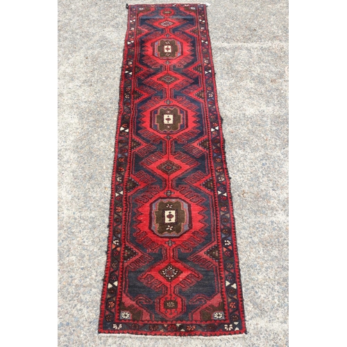 1300 - Old handwoven hall runner of red ground, approx 296 x 71cm