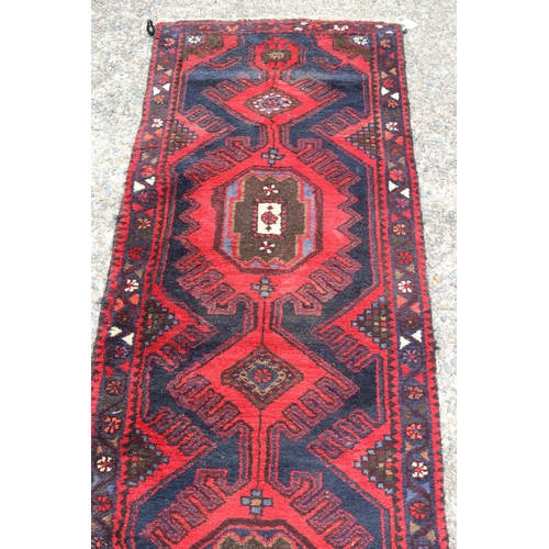 1300 - Old handwoven hall runner of red ground, approx 296 x 71cm